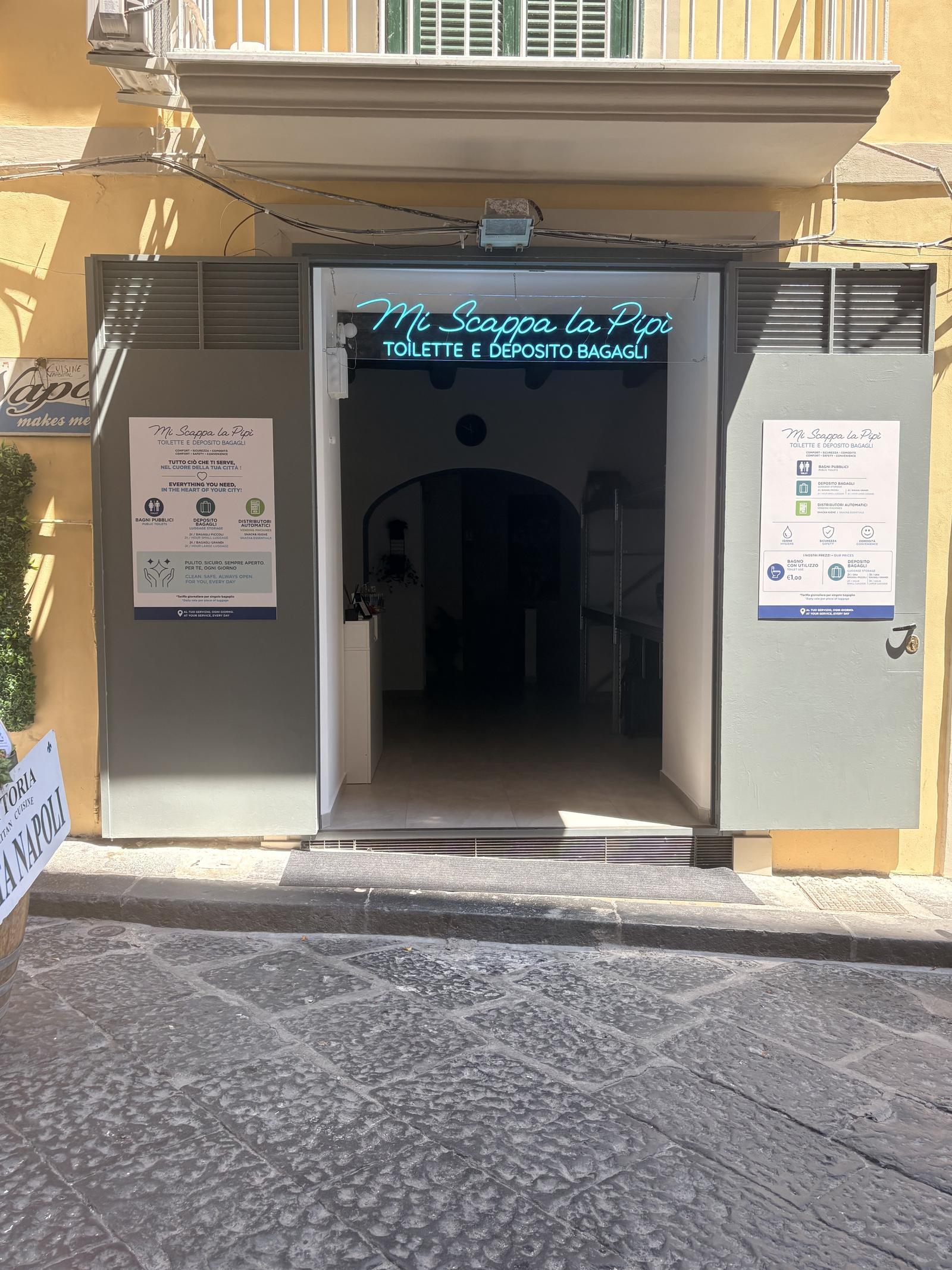 Ingresso di Mi Scappa la Pipì a Napoli, insegna al neon azzurra su Vico Mastellone